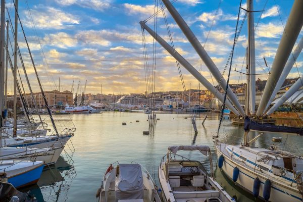 GENOA, ITALY - MARCH 20, 2021: View of port of Genoa with Porto Antico, boats and the colorful houses on italian coastline.