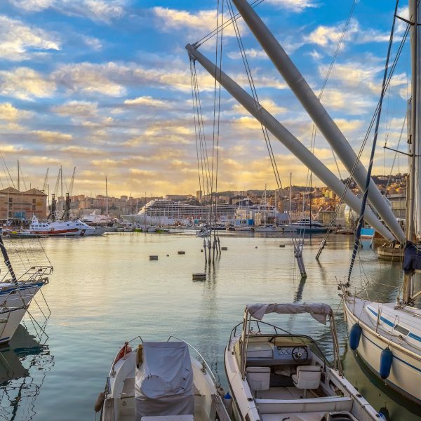 GENOA, ITALY - MARCH 20, 2021: View of port of Genoa with Porto Antico, boats and the colorful houses on italian coastline.